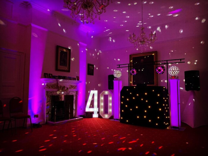 A DJ set up in the Salisbury room with disco balls and lighting, and a giant 40 in lights