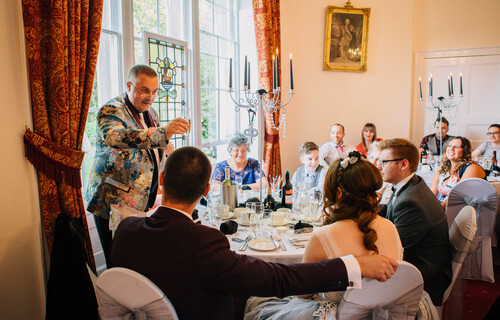 an inside shot of the salisbury room where guests are enjoying a meal, a man in a colourful jacket is stood up making a toast
