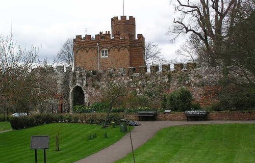 The moat gardens at Hertford Castle. In the foreground is a pathway leading to the curtain wall. The Gatehouse can been seen in the background.