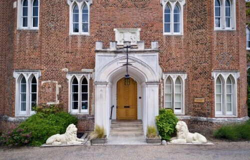 Close up picture of the castle's front entrance, with the stone lions either side of the white stone arch, through which you can see a wooden door