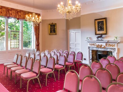 The robing room with a large red velvet covered table, the original brick and timber wall