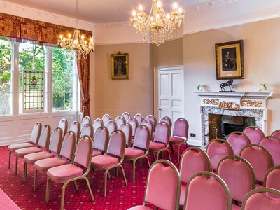 The robing room with a large red velvet covered table, the original brick and timber wall