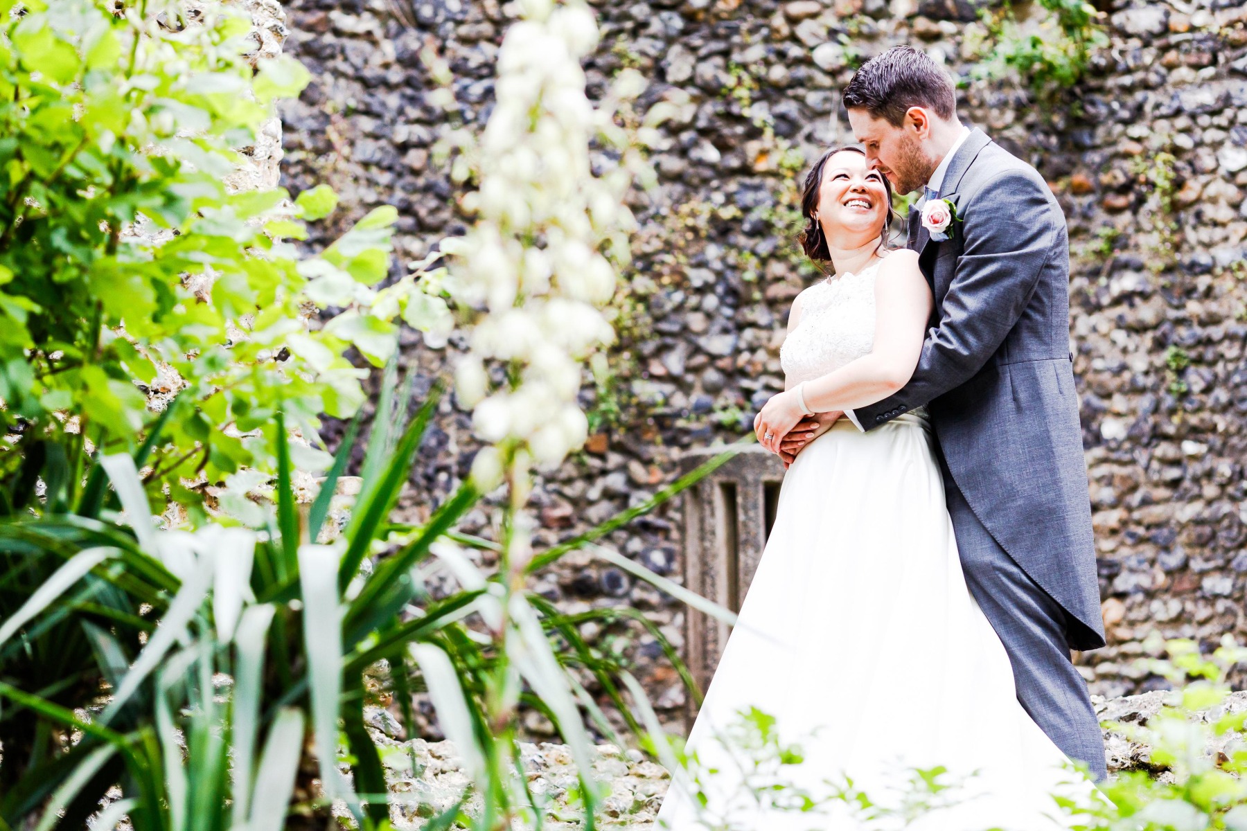 A couple look at each other lovingly in front of the flint Curtain wall