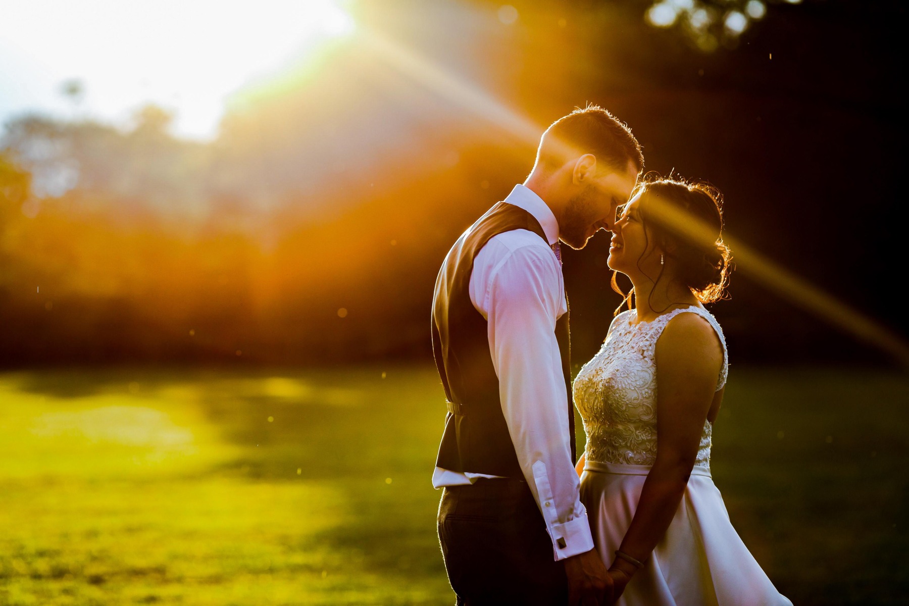 At sunset a couple looking deeply into each other's eyes whilst smiling