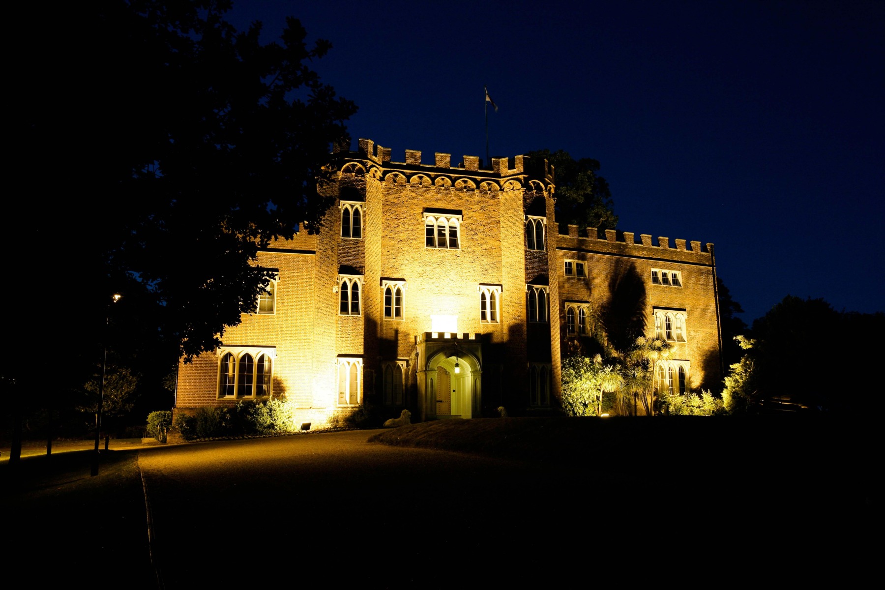 A front shot of Hertford Castle at night, light up by the up lighters.
