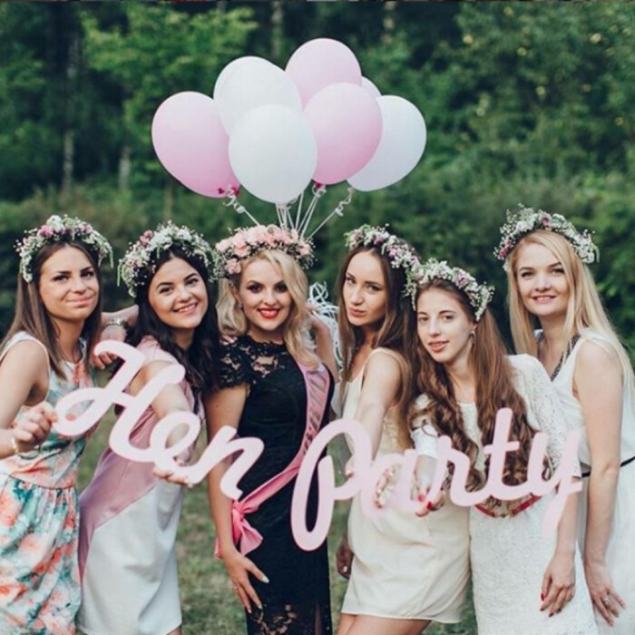 A hen party smiling at the camera holding a 