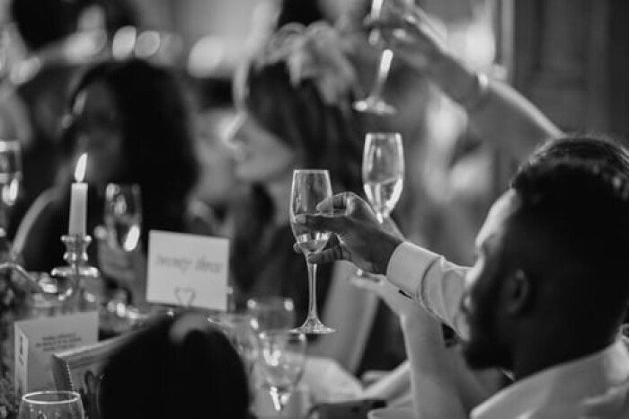 A black and white photo of guests toasting with champagne flutes