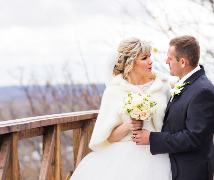 A shot of a Bride and Groom standing on a bridge